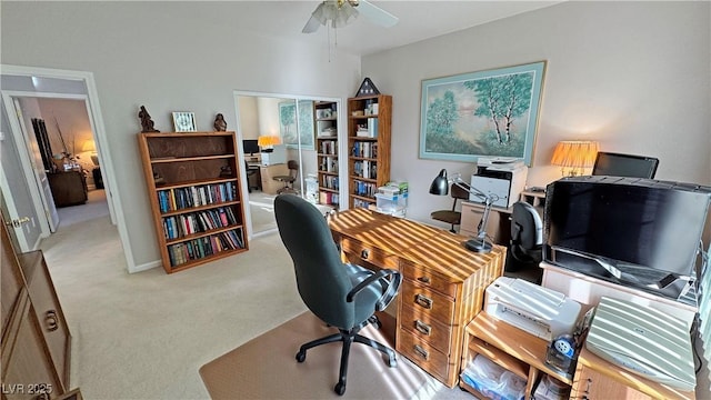 carpeted home office with a ceiling fan