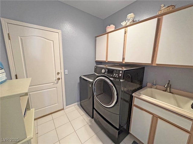 laundry area with cabinet space, a sink, washer and clothes dryer, and light tile patterned flooring