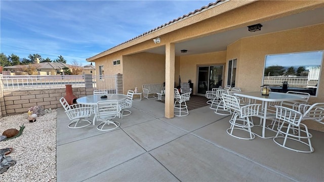 view of patio with outdoor dining space and fence