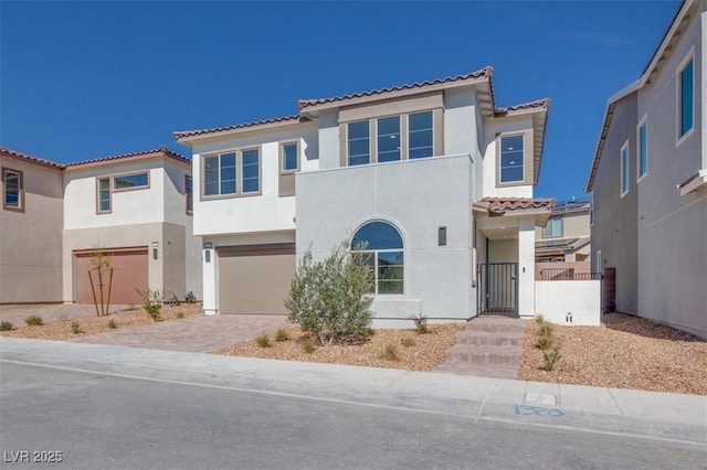 mediterranean / spanish-style house with driveway, an attached garage, and stucco siding