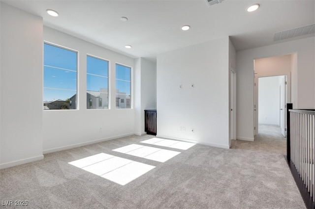 carpeted empty room featuring recessed lighting, visible vents, and baseboards