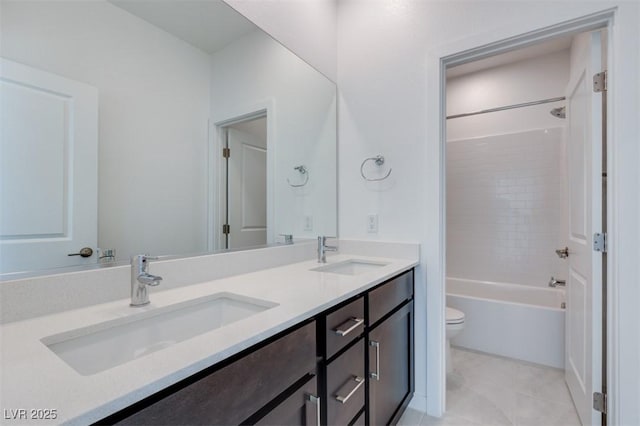 bathroom with double vanity, shower / bath combination, a sink, and toilet