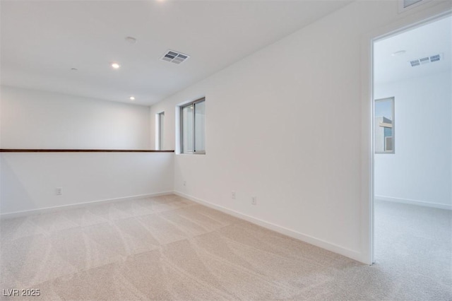 empty room with light carpet, baseboards, and visible vents