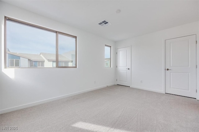 carpeted spare room with baseboards and visible vents