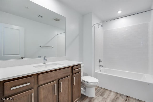 full bathroom featuring visible vents, toilet, wood finished floors, tub / shower combination, and vanity