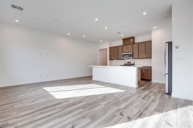 kitchen with stainless steel appliances, open floor plan, and visible vents