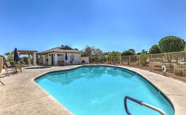 community pool featuring fence, a community hot tub, and a patio