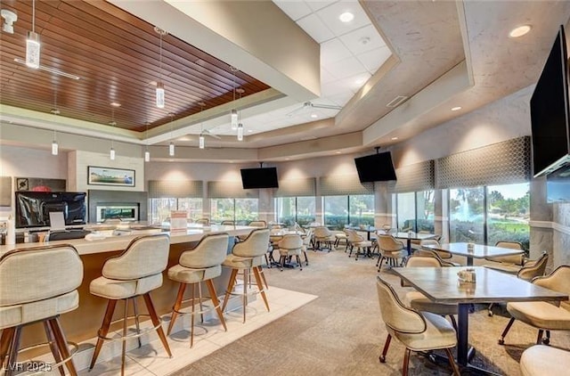 dining area with a raised ceiling and carpet flooring