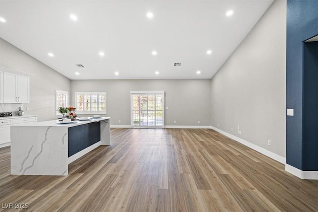 kitchen featuring a large island, recessed lighting, visible vents, light wood-style flooring, and white cabinetry