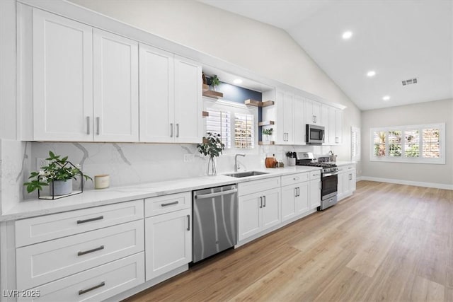 kitchen with open shelves, stainless steel appliances, visible vents, white cabinetry, and a sink