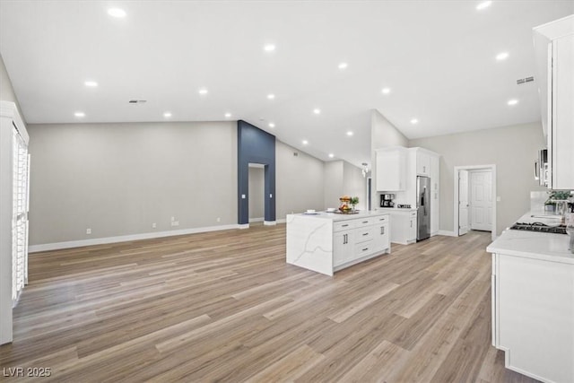 kitchen with light wood-type flooring, open floor plan, white cabinets, and recessed lighting