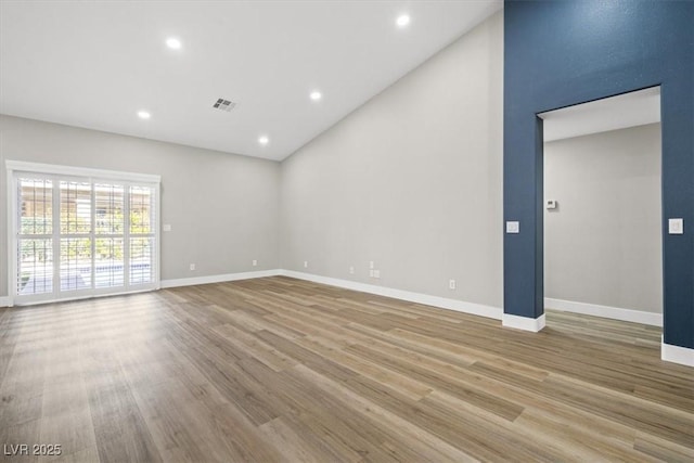 unfurnished room featuring baseboards, visible vents, and wood finished floors