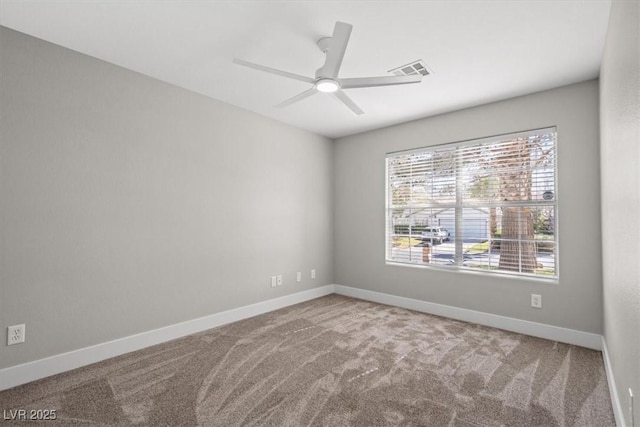 carpeted empty room featuring ceiling fan, visible vents, and baseboards