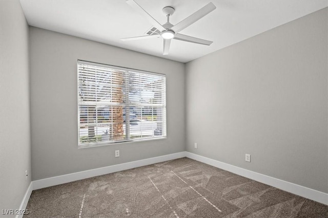 carpeted spare room with a ceiling fan and baseboards