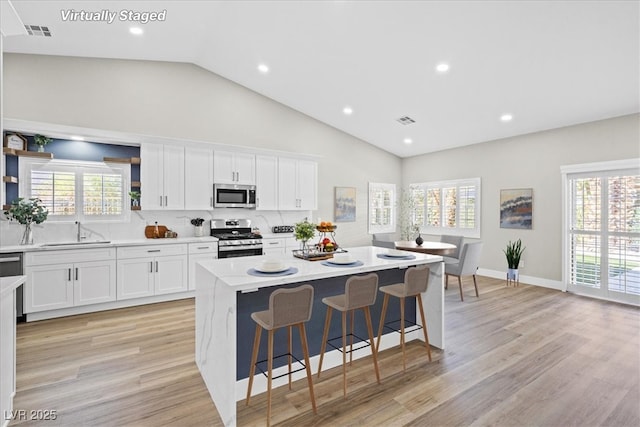 kitchen with appliances with stainless steel finishes, a sink, visible vents, and a healthy amount of sunlight