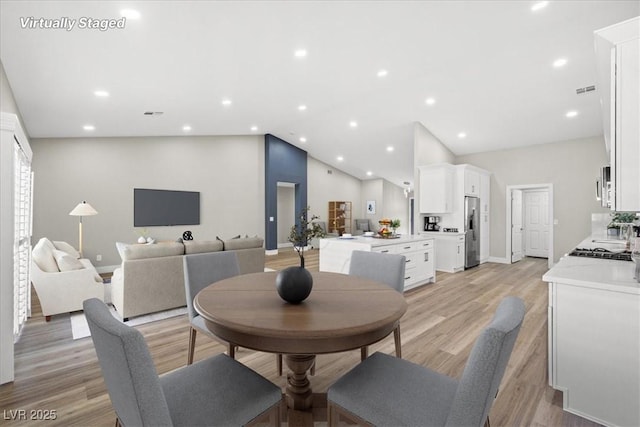 dining area featuring vaulted ceiling, recessed lighting, visible vents, and light wood-style floors