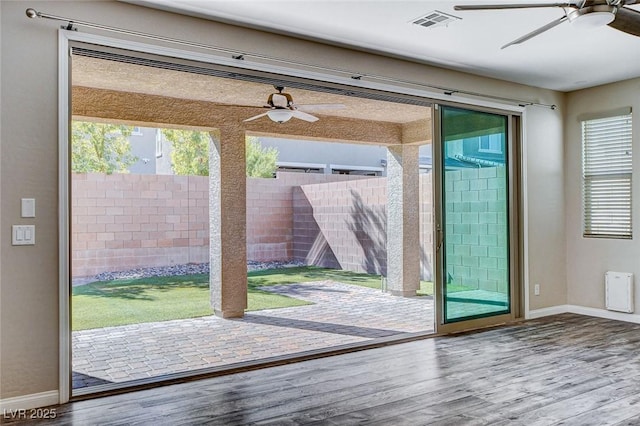 entryway featuring baseboards, wood finished floors, visible vents, and a ceiling fan