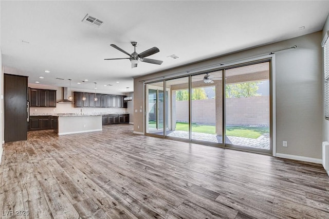 unfurnished living room with baseboards, visible vents, a ceiling fan, wood finished floors, and recessed lighting