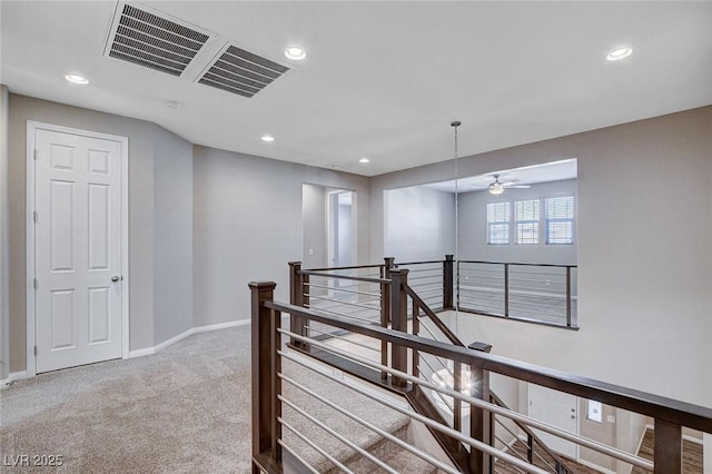 hall with recessed lighting, carpet, baseboards, and an upstairs landing