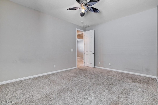 carpeted empty room with visible vents, a ceiling fan, and baseboards