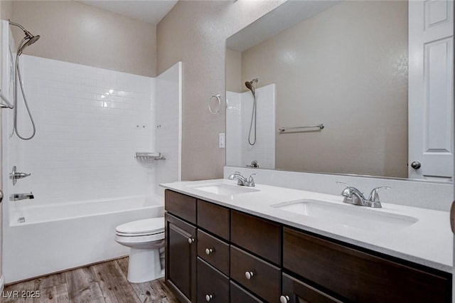 bathroom featuring toilet, shower / washtub combination, a sink, and wood finished floors