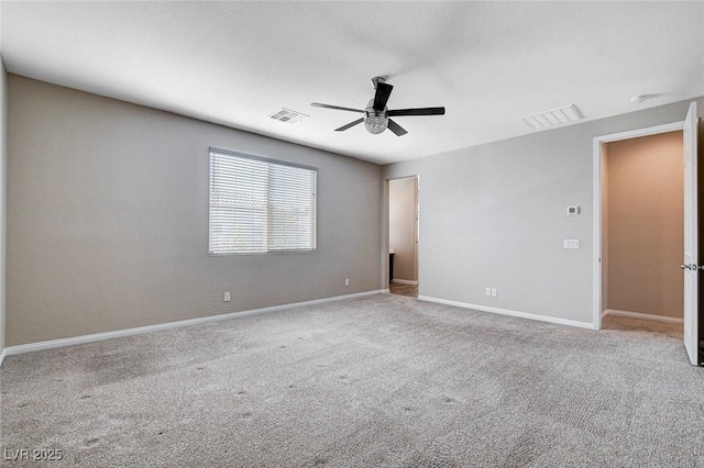 carpeted empty room featuring baseboards, visible vents, and a ceiling fan