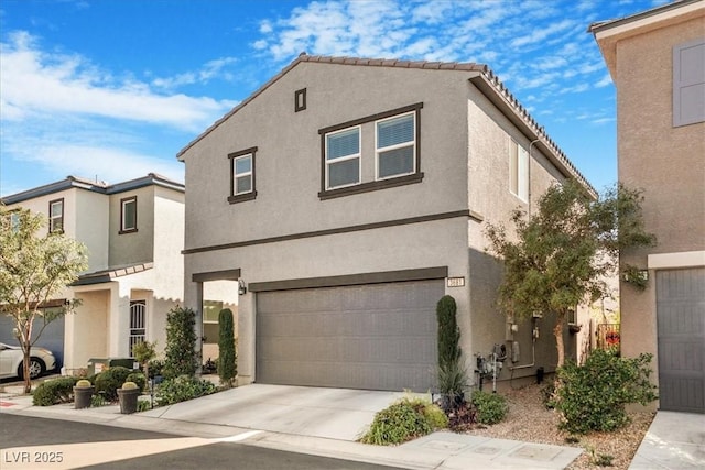 view of front facade with concrete driveway, an attached garage, and stucco siding