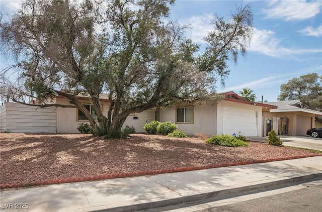 single story home with a garage, driveway, and stucco siding