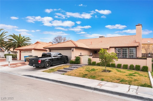 view of front of property featuring a garage, a tile roof, concrete driveway, stucco siding, and a front yard