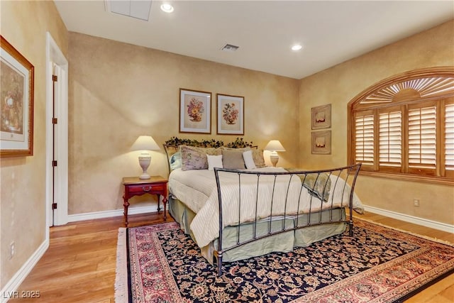 bedroom featuring visible vents, baseboards, wood finished floors, and recessed lighting