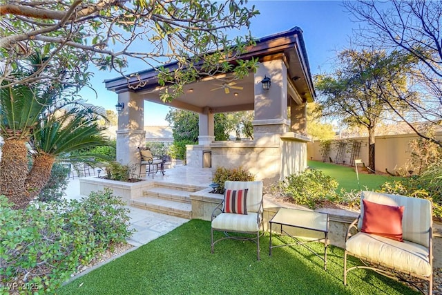 view of patio featuring fence and a ceiling fan