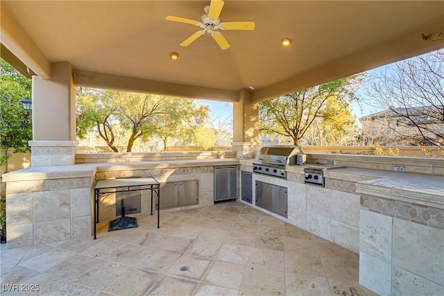 view of patio / terrace with a ceiling fan, a grill, and an outdoor kitchen