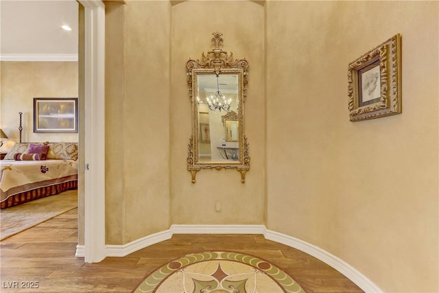 hall with baseboards, wood finished floors, and ornamental molding