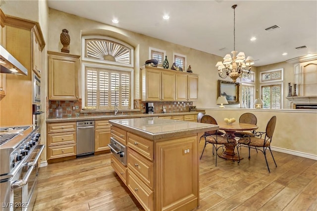 kitchen featuring light wood-style flooring, light brown cabinets, appliances with stainless steel finishes, and tasteful backsplash