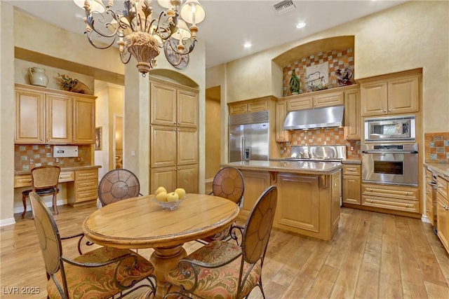 dining space with light wood finished floors, visible vents, built in desk, and recessed lighting