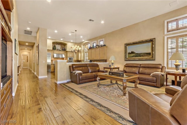 living room featuring light wood-style floors, recessed lighting, and visible vents