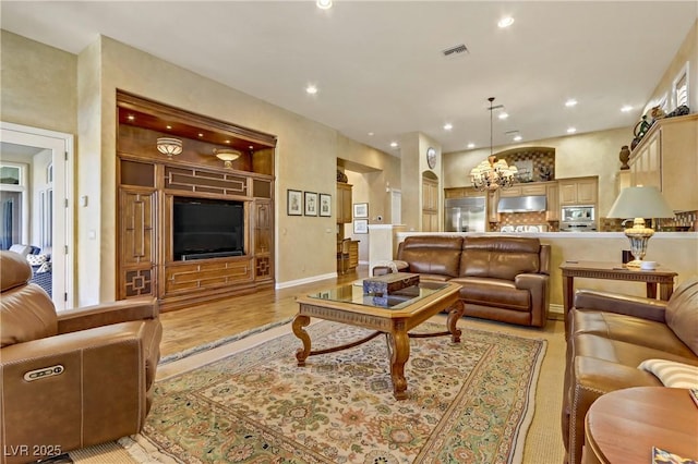 living area with light wood-style floors, visible vents, and recessed lighting