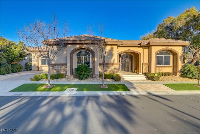 view of front of house with stone siding, driveway, and stucco siding