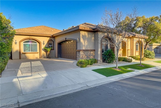 mediterranean / spanish-style house with a garage, concrete driveway, stone siding, and stucco siding