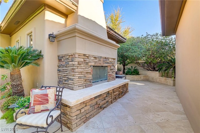 view of patio / terrace featuring an outdoor stone fireplace