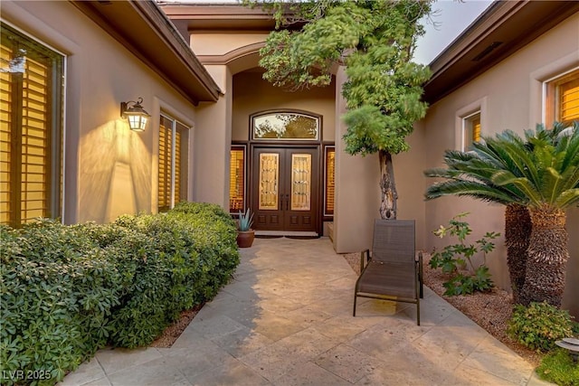 property entrance featuring french doors and stucco siding