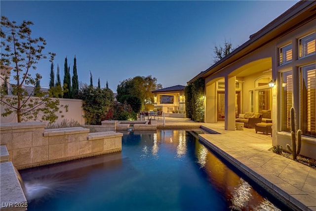 outdoor pool with a patio area and an outdoor living space