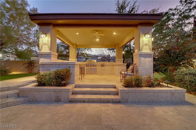 view of patio / terrace with ceiling fan, exterior kitchen, a grill, and fence