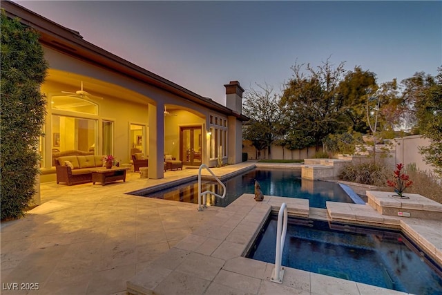 pool at dusk featuring a fenced backyard, outdoor lounge area, french doors, and an in ground hot tub