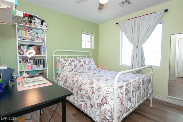 bedroom featuring a ceiling fan, baseboards, visible vents, and wood finished floors