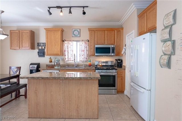 kitchen with appliances with stainless steel finishes, crown molding, a sink, and light tile patterned floors