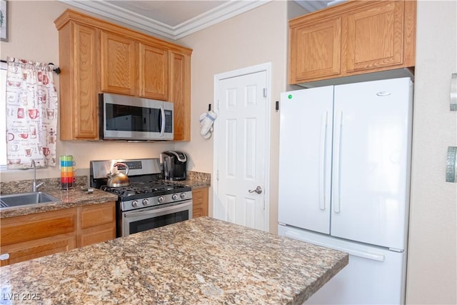 kitchen featuring ornamental molding, appliances with stainless steel finishes, stone counters, and a sink