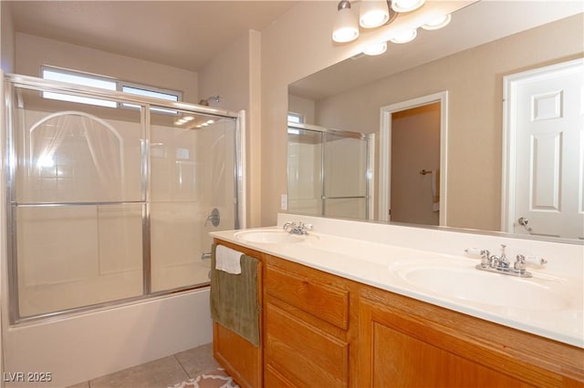 bathroom featuring double vanity, tile patterned flooring, combined bath / shower with glass door, and a sink