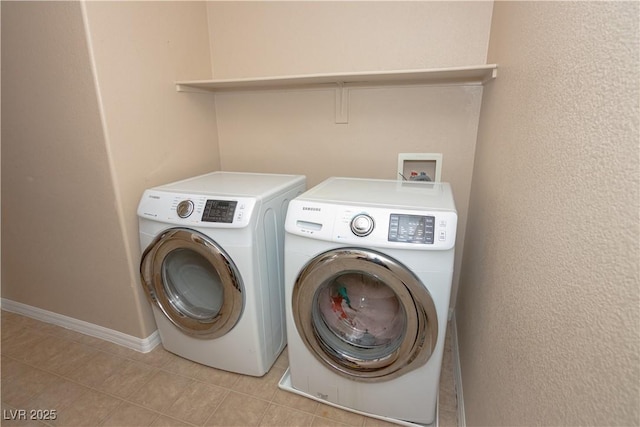 washroom featuring laundry area, light tile patterned floors, baseboards, and independent washer and dryer