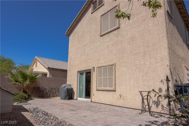 back of house featuring stucco siding, a tiled roof, fence, and a patio